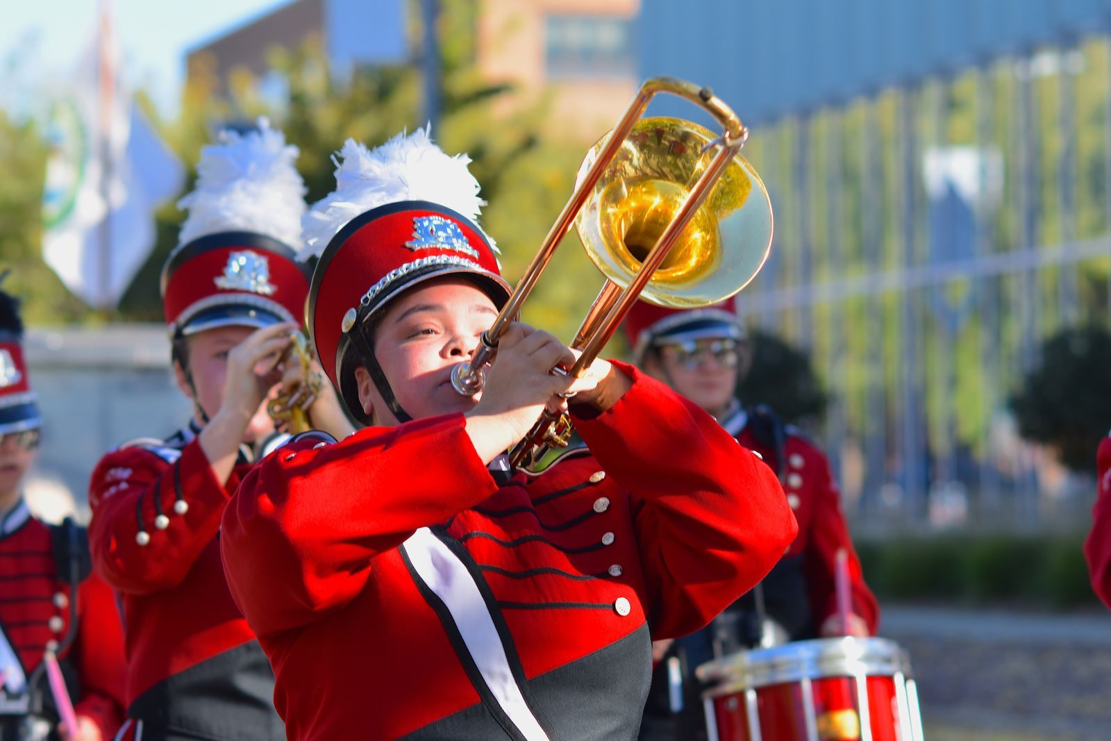 High school marching band members in red uniforms playing trombones, the kind of group that plans a school trip cruise